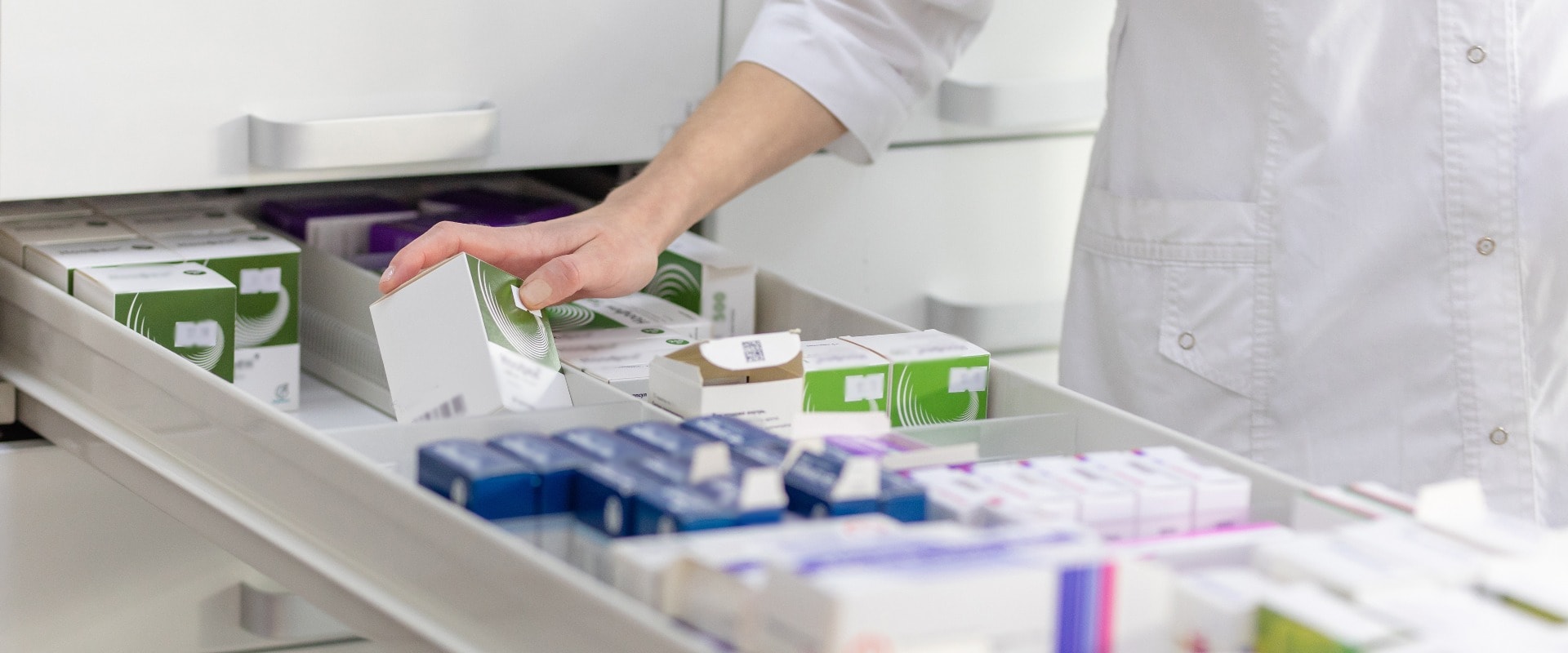 Apotheker nimmt Medikamente aus einer Schublade