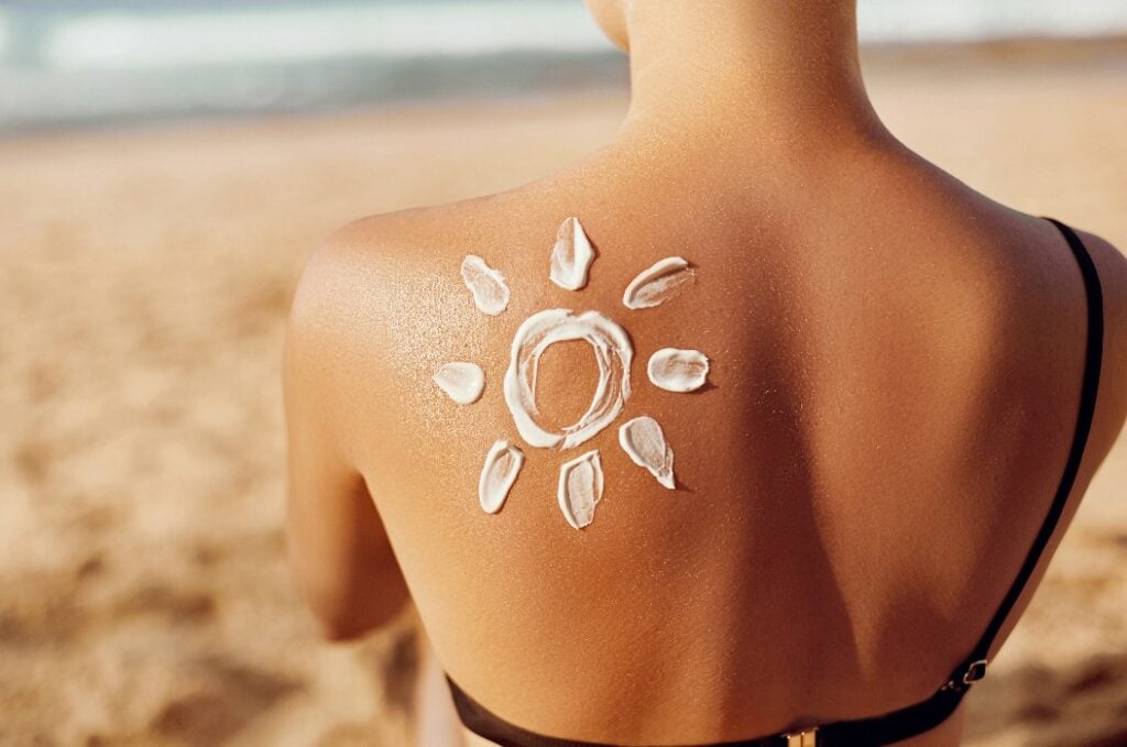 Frau mit Sonne aus Sonnencreme auf dem Rücken