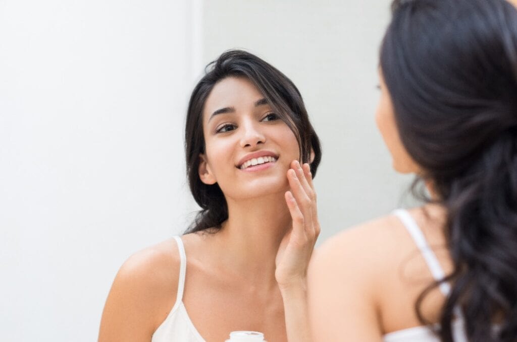 Woman applying moisturizer