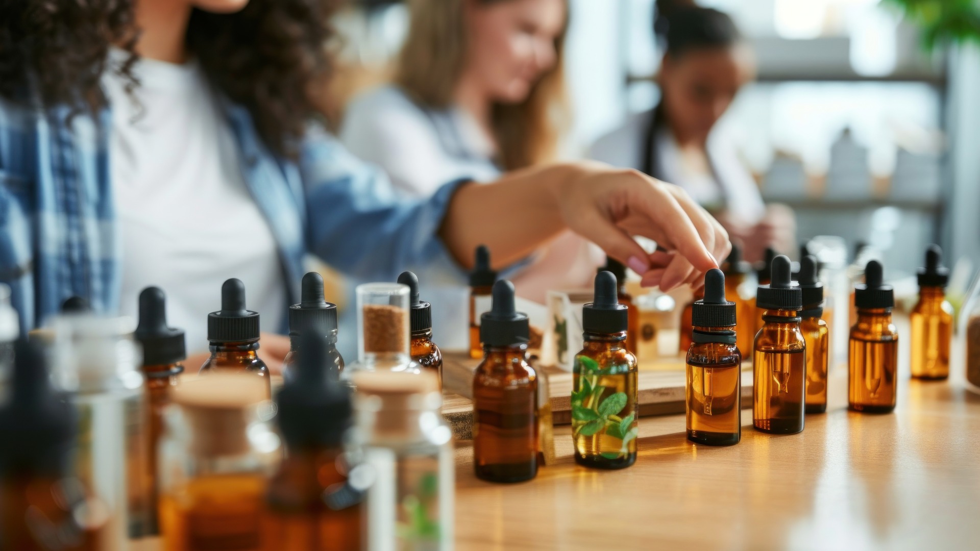 Eine Frau erklärt Produkte in einem Workshop für ätherische Öle, umgeben von Regalen mit abgefüllten Ölen.