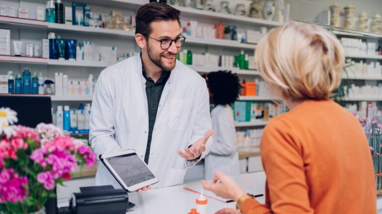Porträt eines Apothekers, der am Tresen einer Apotheke arbeitet